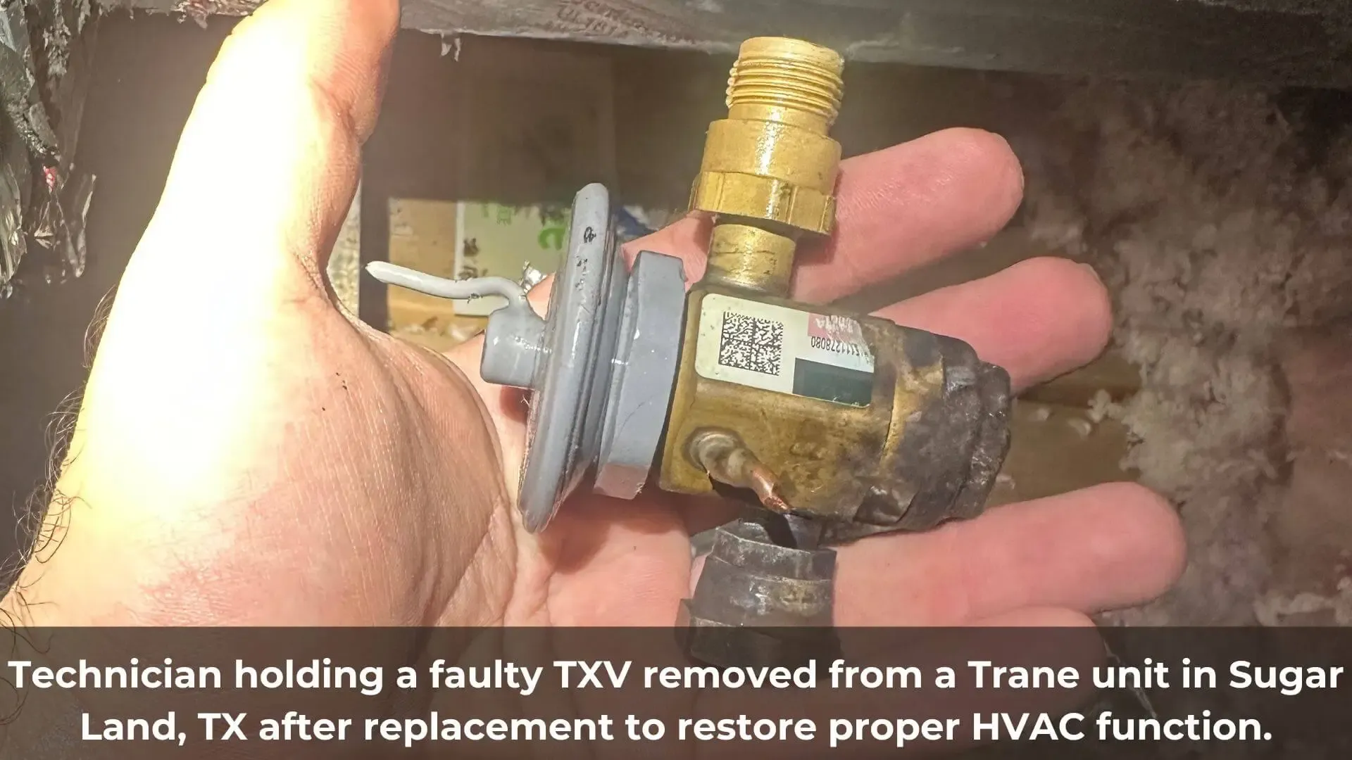 Technician holding a faulty TXV removed from a Trane unit in Sugar Land TX after replacement to restore proper HVAC function
